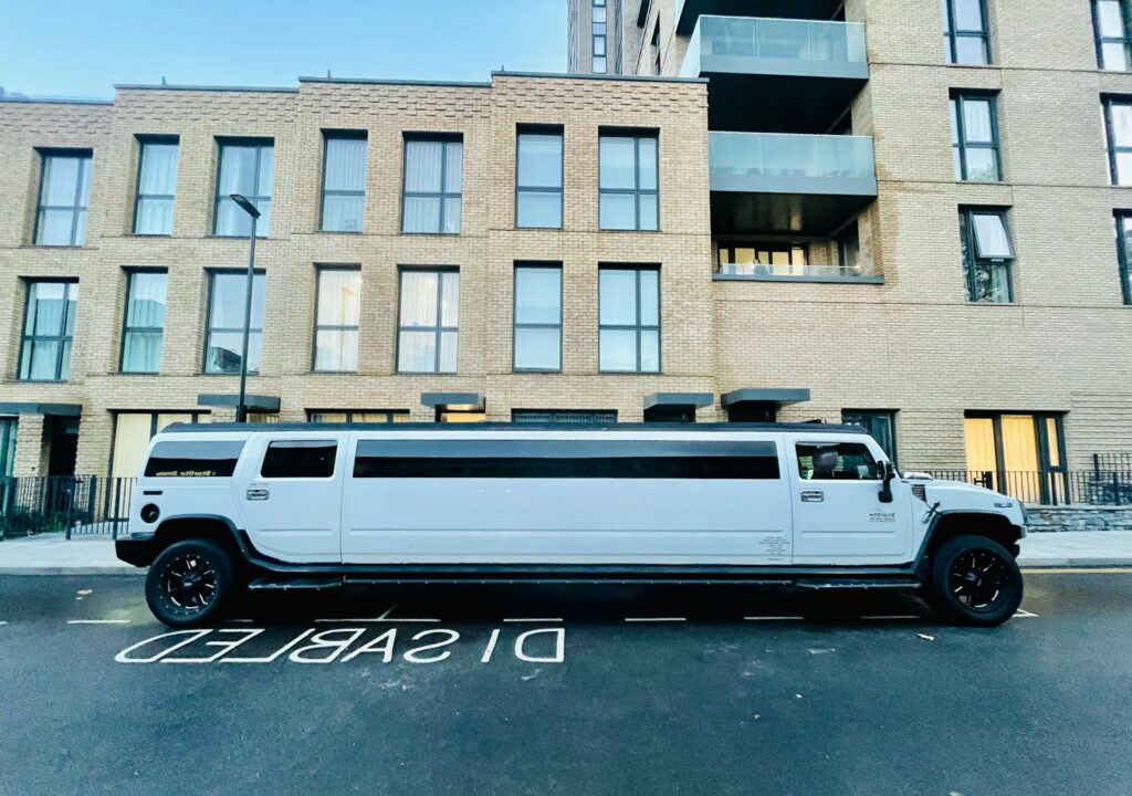 A sleek white Hummer limo parked in an urban setting, representing one of the luxurious options for airport transfers Budapest stags, ideal for making a grand entrance.